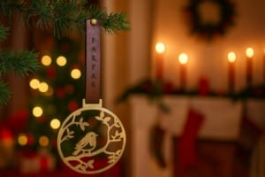 Juleornament i messing med lille fugl på gren